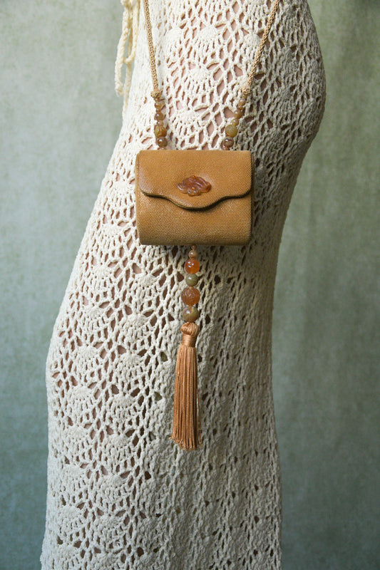 hard case purse with carved jade tone accents and tassel